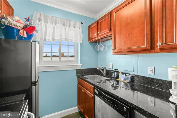a kitchen with stainless steel appliances granite countertop a sink and a refrigerator