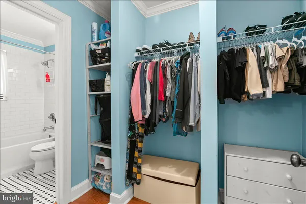 a view of walk in closet with clothes and shoes