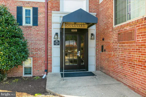 a view of a brick house with a door and a large window