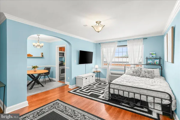 a bedroom with a bed a couch and a flat screen tv