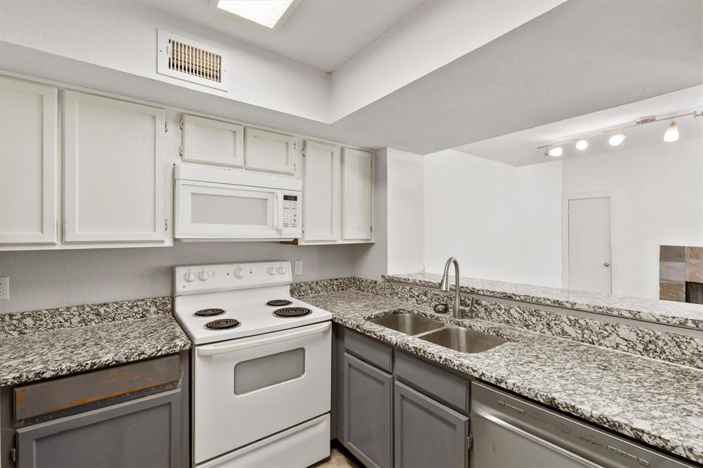 9807 Walnut Street, Unit 202 Dallas, TX 75243 - Photo 5 of 16 a kitchen with granite countertop a sink and cabinets