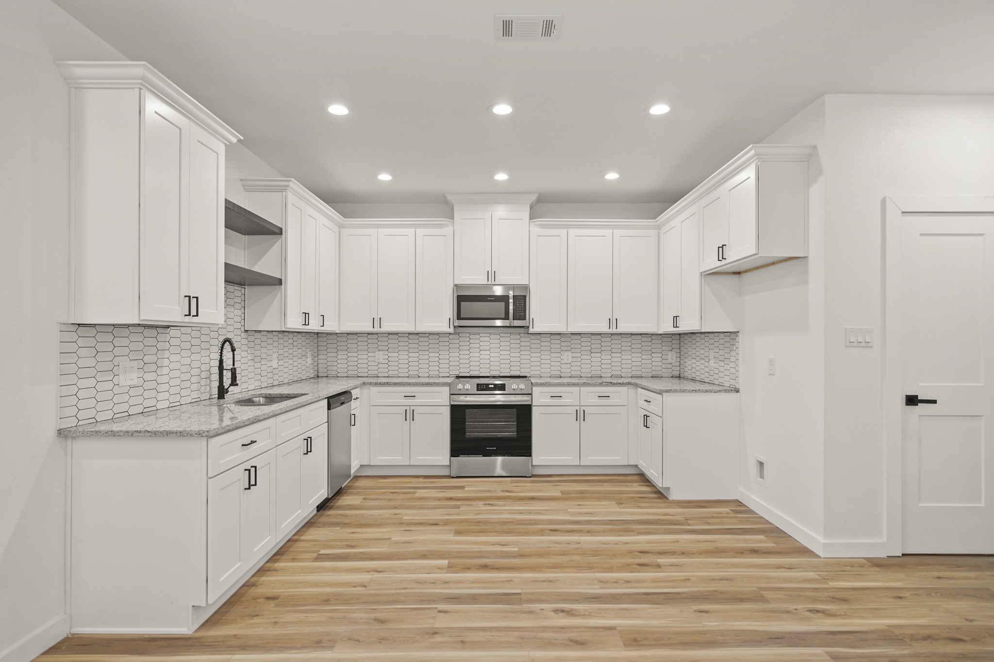 6206 Lyndhurst Drive, Unit AB Houston, TX 77087 - Photo 2 of 14 a large kitchen with stainless steel appliances granite countertop a stove top oven a sink dishwasher and a refrigerator with wooden floor