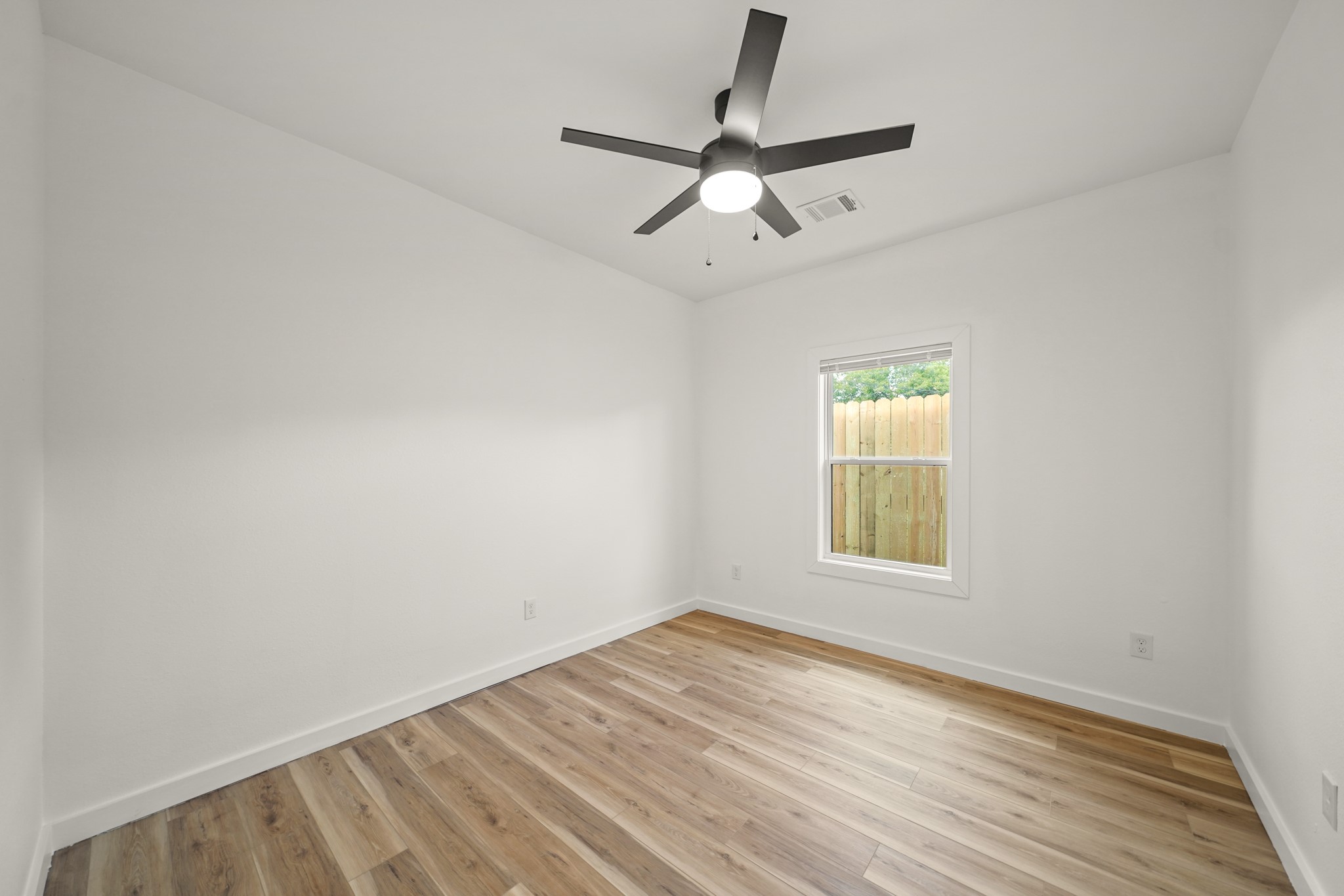 6206 Lyndhurst Drive, Unit AB Houston, TX 77087 - Photo 10 of 14 wooden floor in an empty room with a window