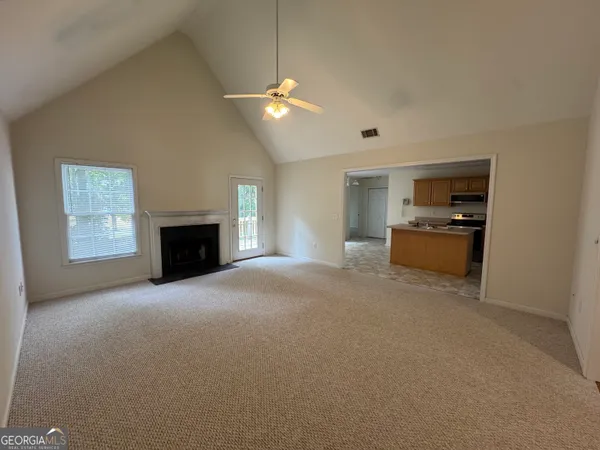 an empty room with fireplace and a window