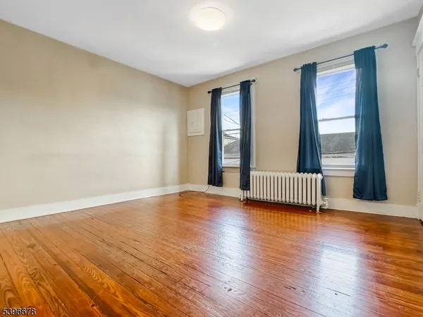 a view of a room with wooden floor and windows