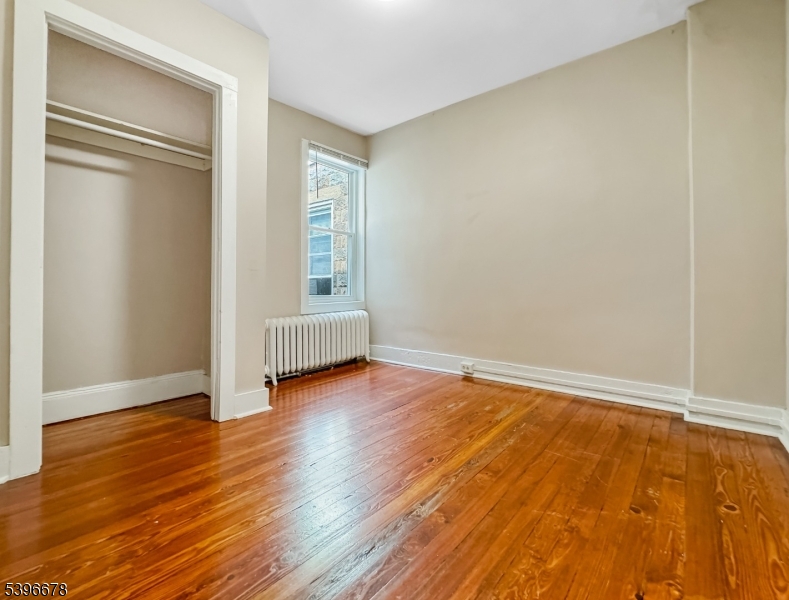 83 Jefferson Street, Unit B Phillipsburg, NJ 08865 - Photo 4 of 10 an empty room with wooden floor and windows