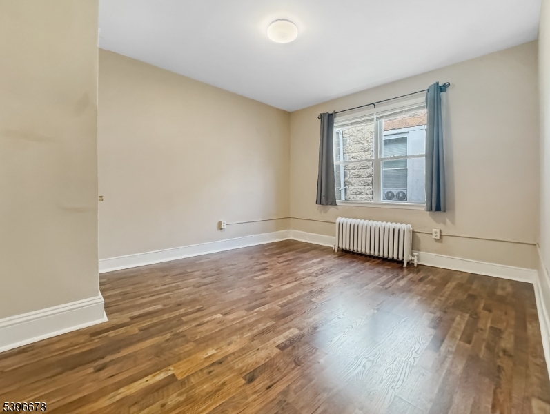 83 Jefferson Street, Unit B Phillipsburg, NJ 08865 - Photo 9 of 10 a view of an empty room with wooden floor and a window