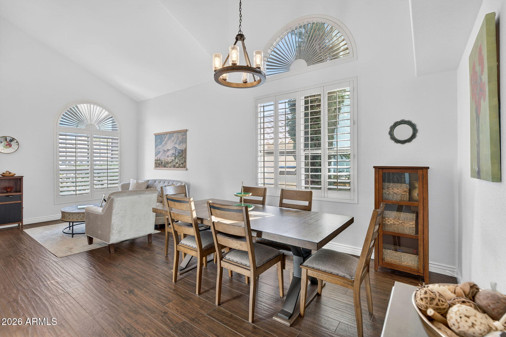 3615 East Desert Willow Road Phoenix, AZ 85044 - Photo 18 of 65 a dining room with wooden floor a chandelier a wooden table and chairs