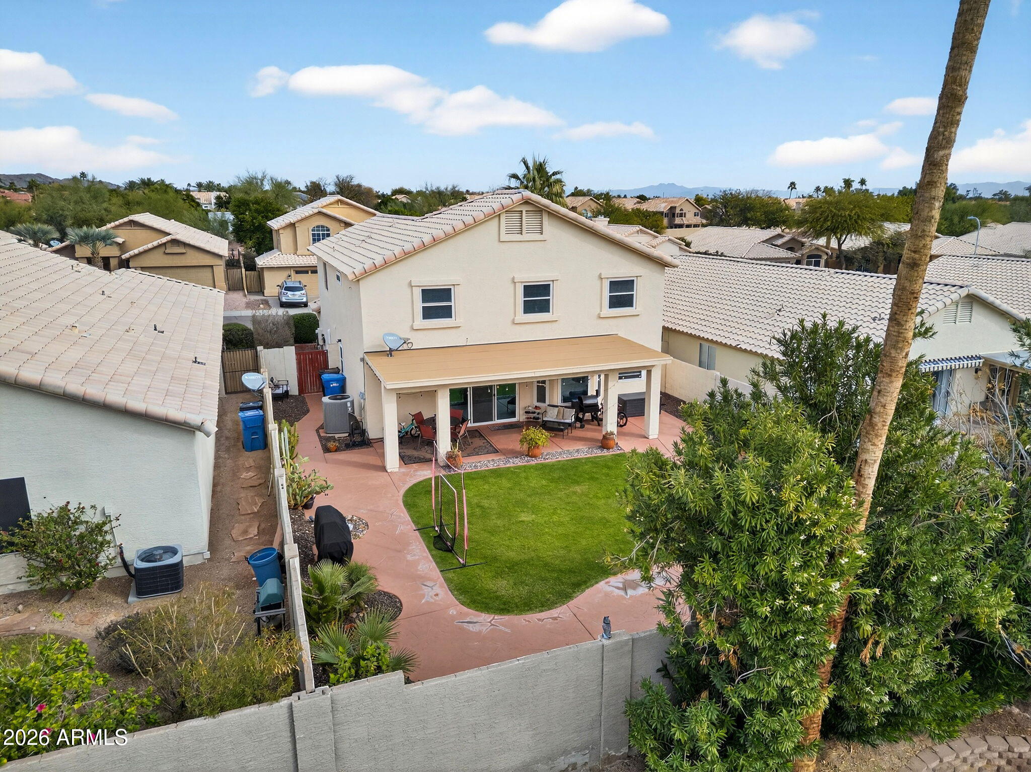 3615 East Desert Willow Road Phoenix, AZ 85044 - Photo 52 of 65 a view of a white house next to a yard with potted plants
