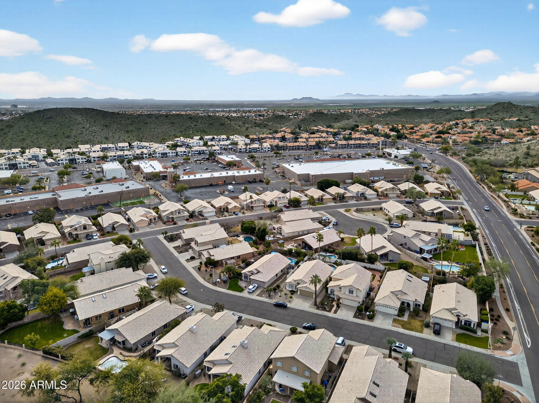 3615 East Desert Willow Road Phoenix, AZ 85044 - Photo 62 of 65 an aerial view of a city with lots of residential buildings and ocean view in back