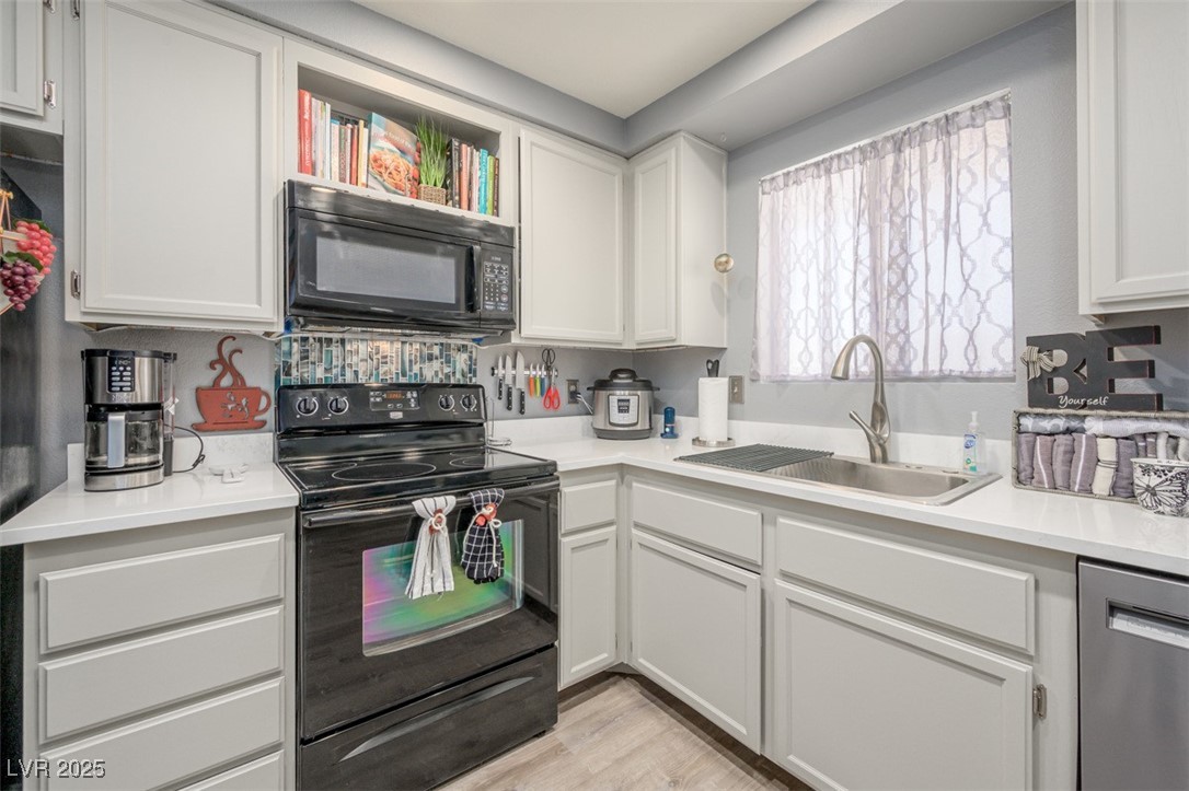 2240 Highpointe Drive, Unit 203 Laughlin, NV 89029 - Photo 23 of 38 Kitchen with a sink, light countertops, white cabinets, and black appliances