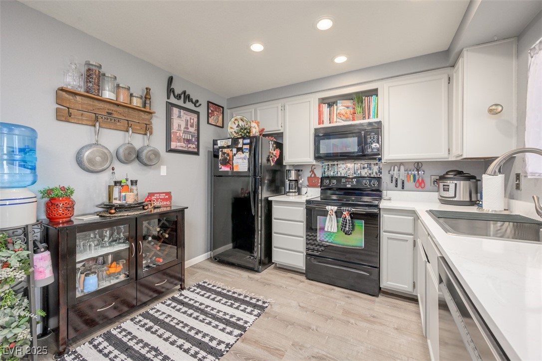 2240 Highpointe Drive, Unit 203 Laughlin, NV 89029 - Photo 25 of 38 Kitchen with white cabinets, a sink, and black appliances