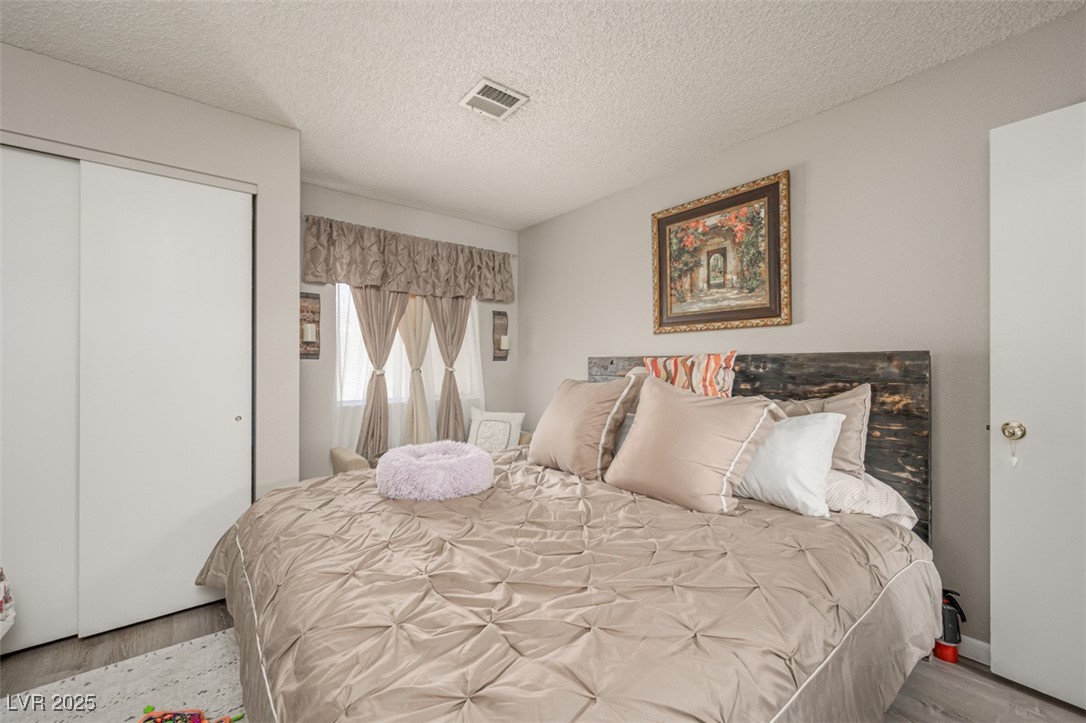 2240 Highpointe Drive, Unit 203 Laughlin, NV 89029 - Photo 30 of 38 Bedroom featuring visible vents, a textured ceiling, wood finished floors, and a closet