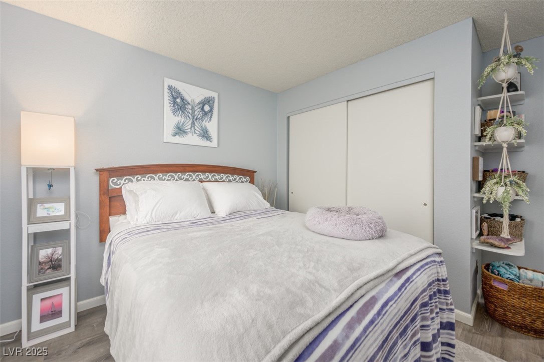 2240 Highpointe Drive, Unit 203 Laughlin, NV 89029 - Photo 31 of 38 Bedroom with a textured ceiling, baseboards, wood finished floors, and a closet