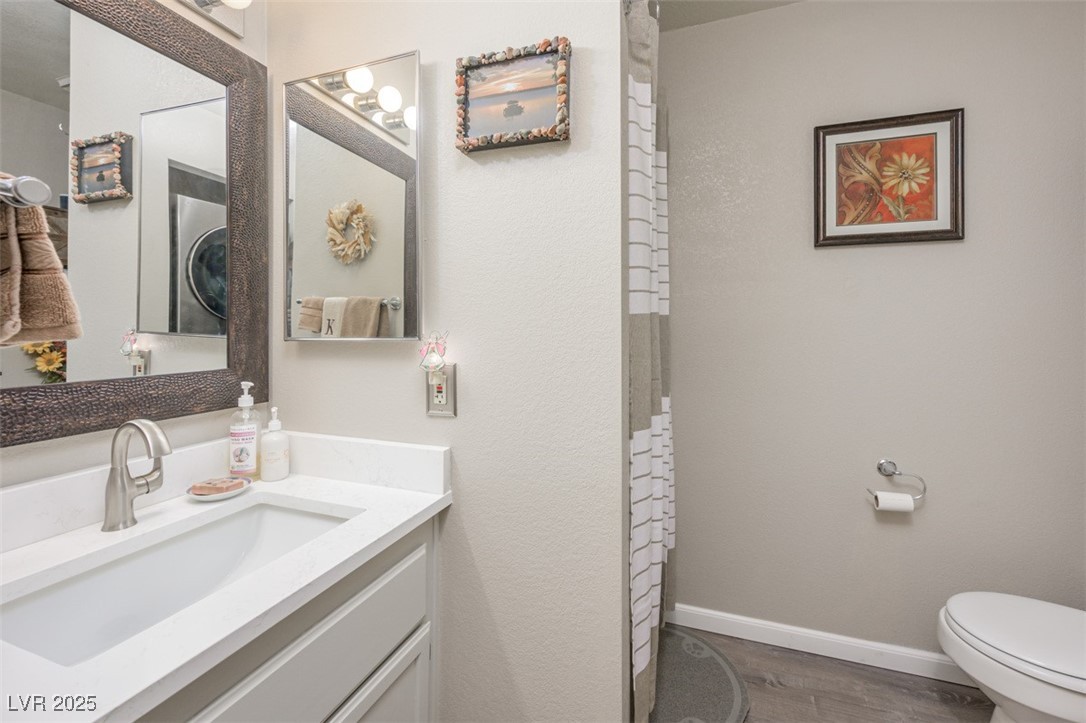2240 Highpointe Drive, Unit 203 Laughlin, NV 89029 - Photo 34 of 38 Bathroom with vanity, baseboards, wood finished floors, and toilet