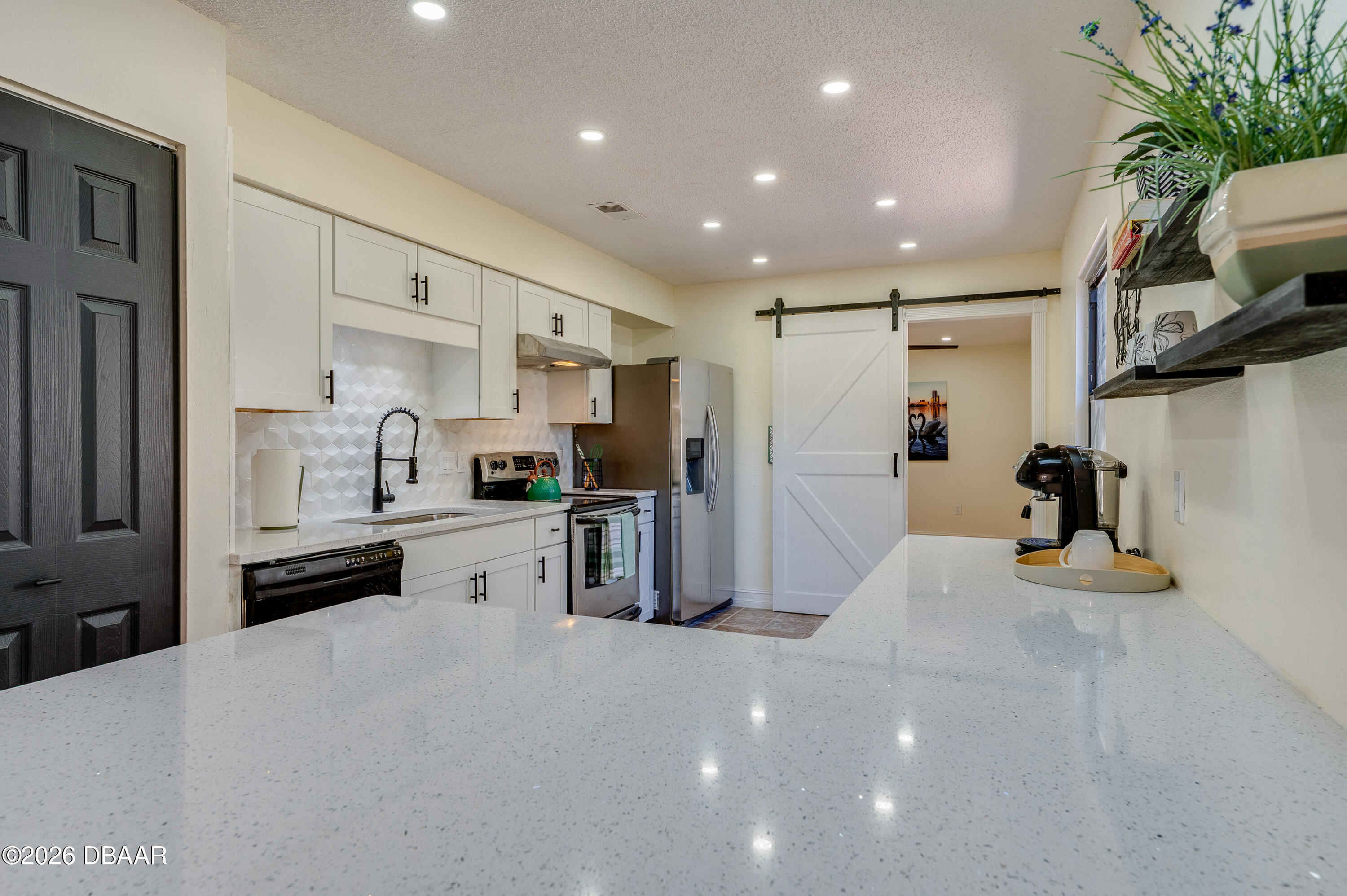 2425 Royal Palm Drive Edgewater, FL 32141 - Photo 12 of 41 a kitchen with stainless steel appliances kitchen island granite countertop a refrigerator and a sink