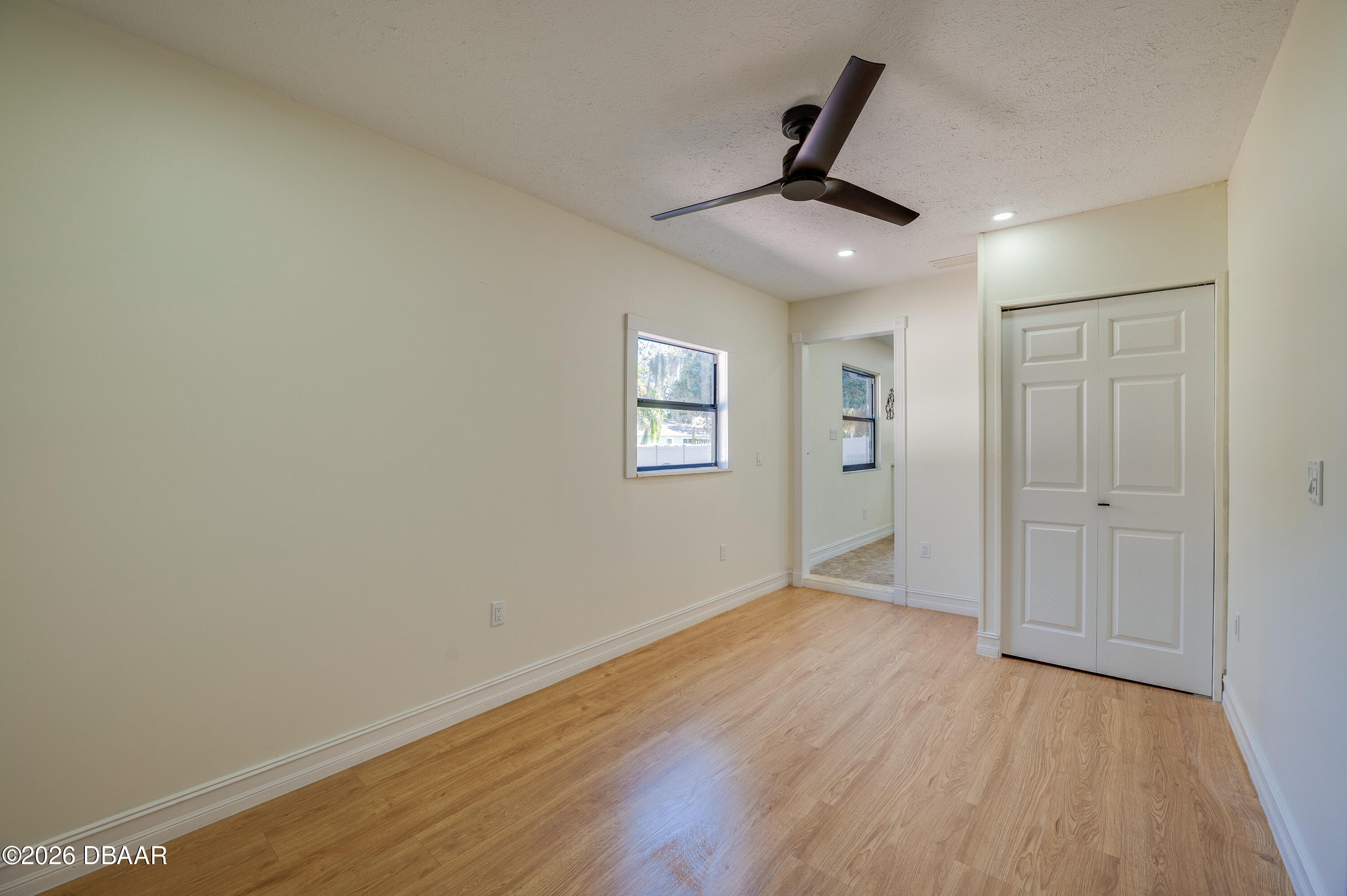 2425 Royal Palm Drive Edgewater, FL 32141 - Photo 28 of 41 an empty room with wooden floor ceiling fan and windows