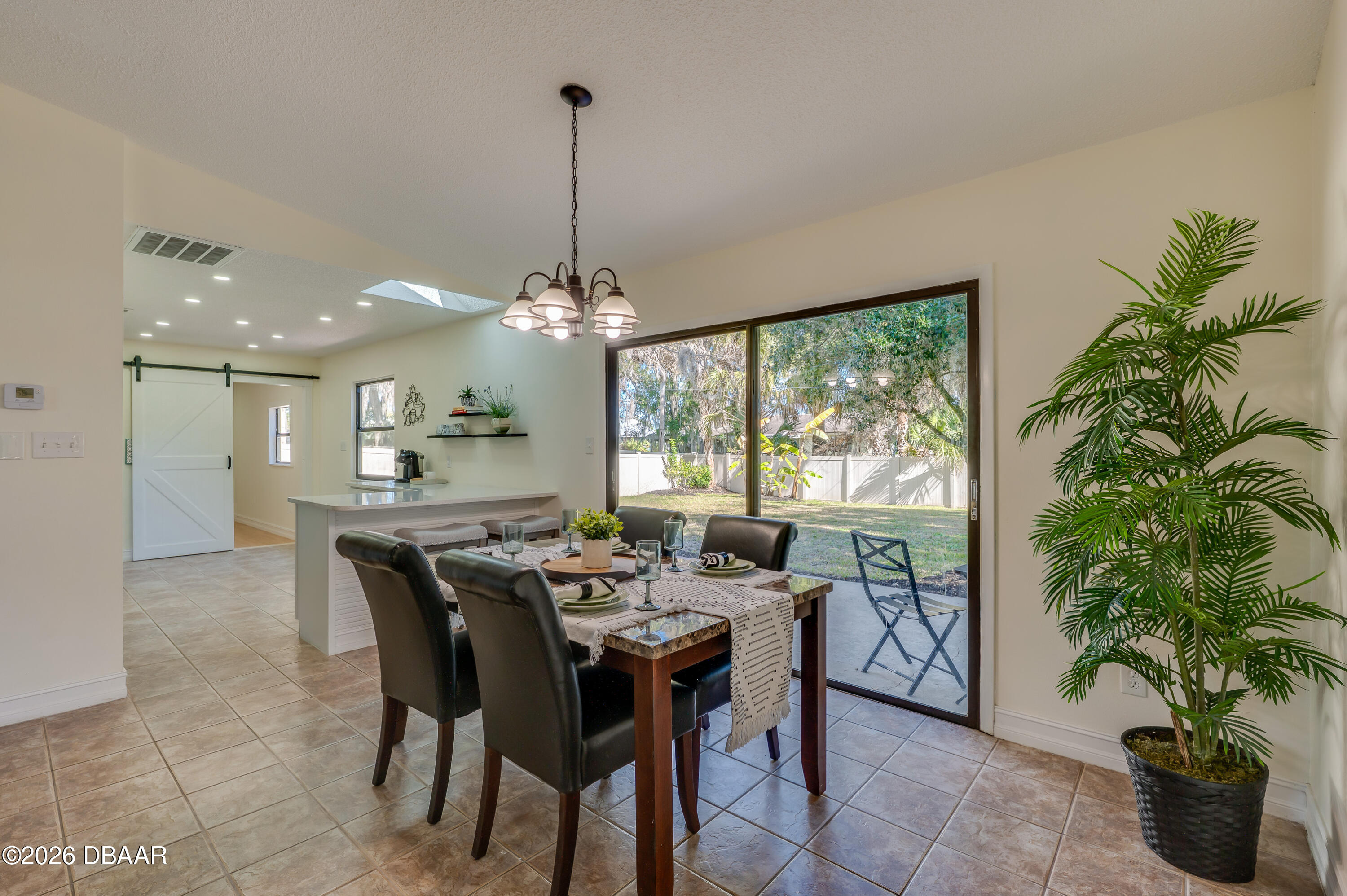 2425 Royal Palm Drive Edgewater, FL 32141 - Photo 10 of 41 a dining room with furniture potted plants and a chandelier