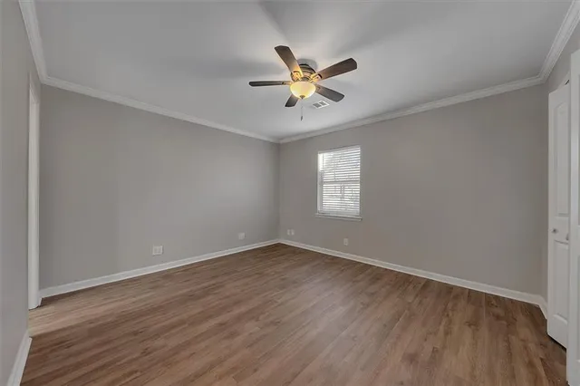 a view of a room with wooden floor fan and windows