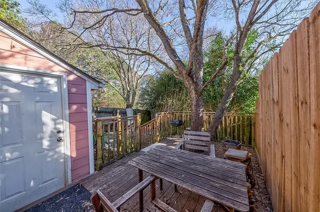a view of a wooden bench with chairs in the patio