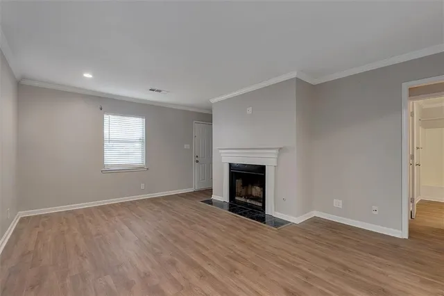 a view of empty room with wooden floor and fireplace