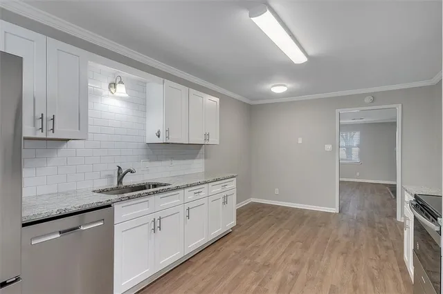 a kitchen with a sink cabinets and wooden floor