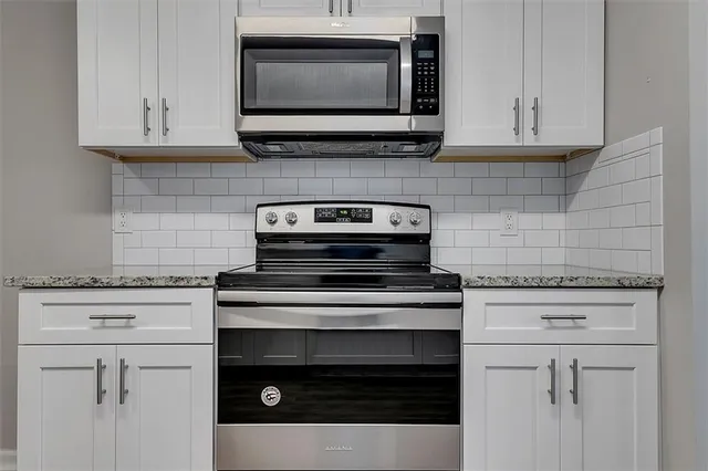 a kitchen with stove top oven and cabinets