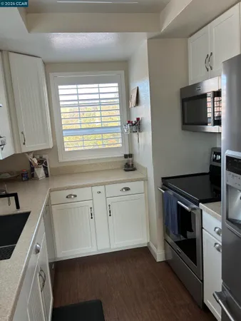 a kitchen with white cabinets stainless steel appliances and sink