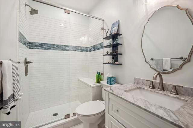 a bathroom with a granite countertop sink a mirror and a toilet
