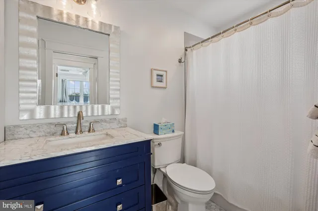 a bathroom with a toilet a sink and a mirror