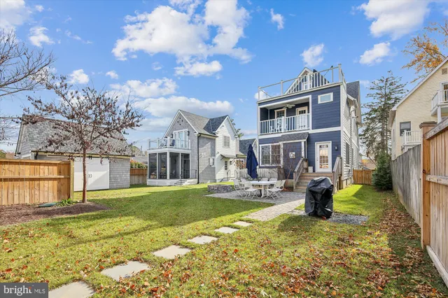 a front view of a house with a yard outdoor seating and covered with trees