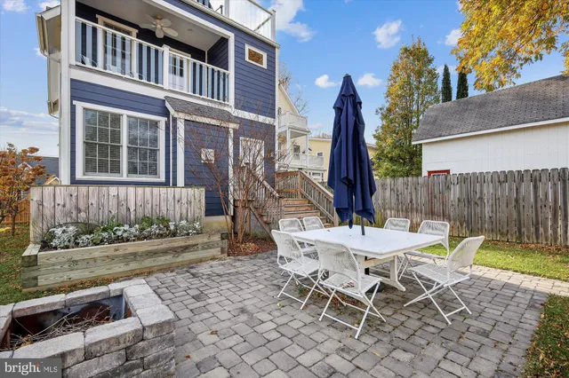 a view of a chair and table in backyard of the house