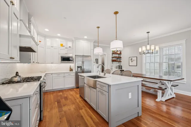 a kitchen with a sink stove and wooden floor