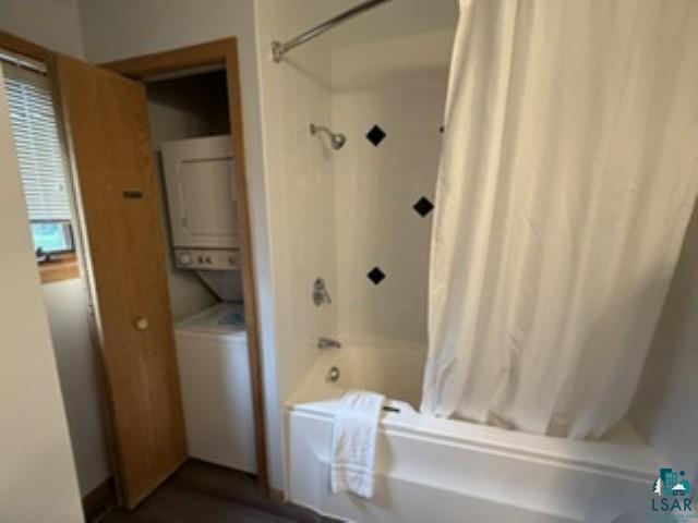 6266 Giants Ridge Road Biwabik, MN 55705 - Photo 12 of 30 Bathtub and shower combination, shower curtain, black accent tiles, integrated stacked washer and dryer unit, wood-finish flooring