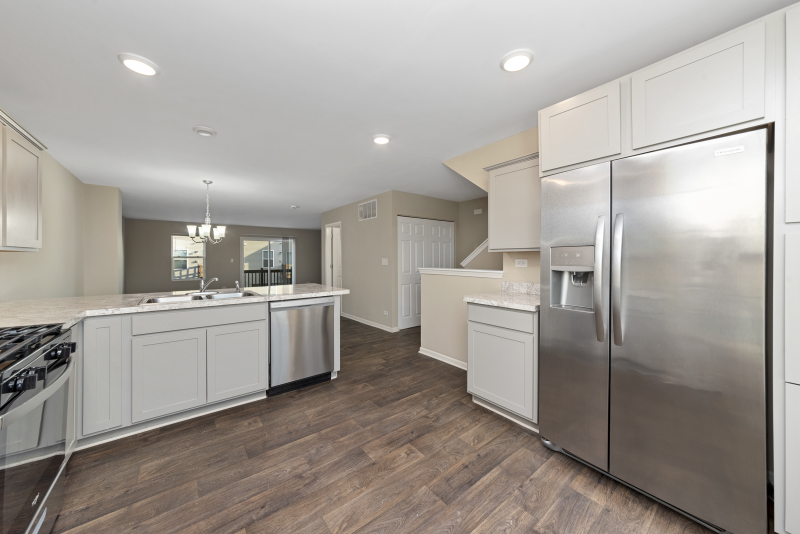 2303 Upland Road Pingree Grove, IL 60140 - Photo 3 of 17 a kitchen with white cabinets and stainless steel appliances