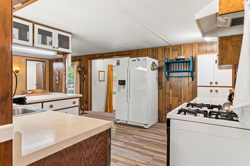 1500 County Road 404 Comanche, TX 76442 - Photo 15 of 39 a kitchen with stainless steel appliances a refrigerator and a stove with white cabinets