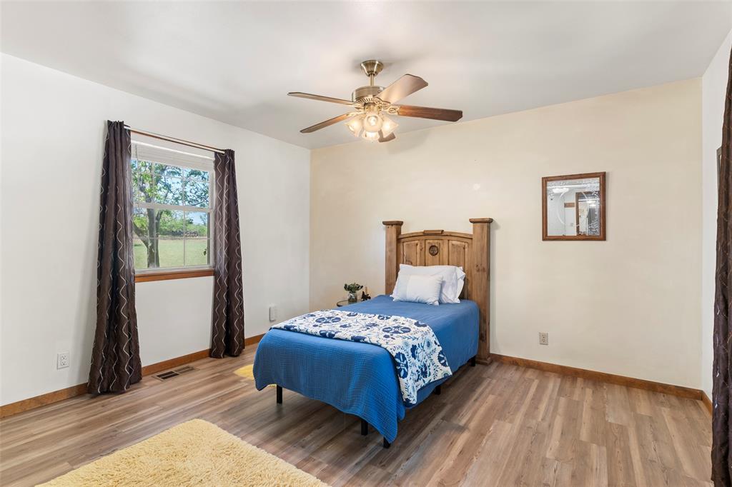 1500 County Road 404 Comanche, TX 76442 - Photo 16 of 39 a bedroom with a bed and wooden floor