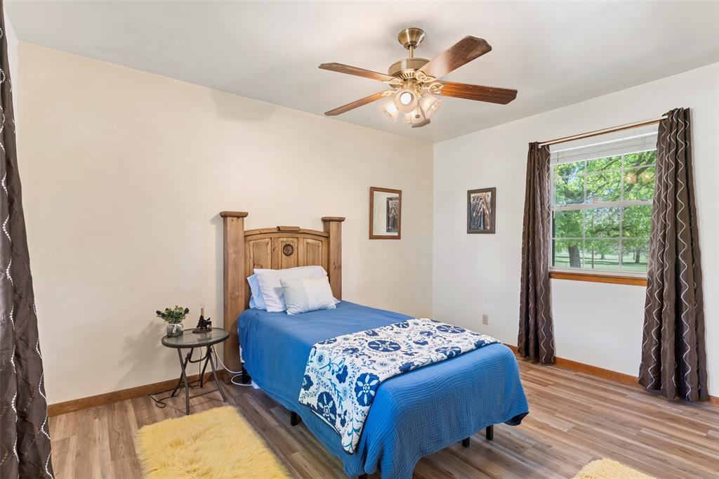 1500 County Road 404 Comanche, TX 76442 - Photo 17 of 39 a bedroom with a large bed and a chandelier