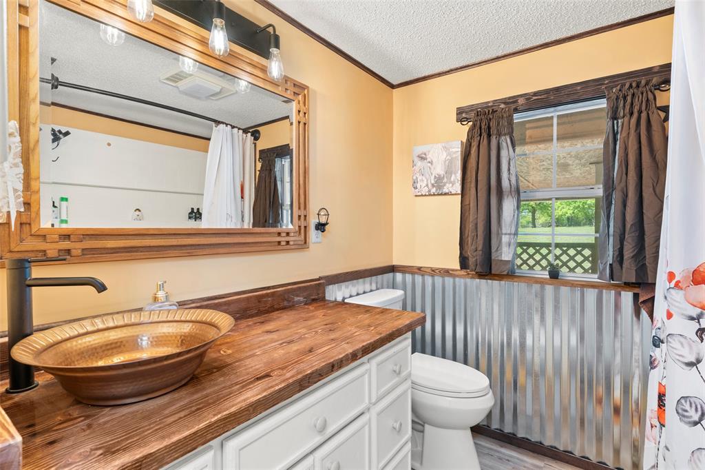 1500 County Road 404 Comanche, TX 76442 - Photo 19 of 39 a bathroom with a sink a toilet and a mirror