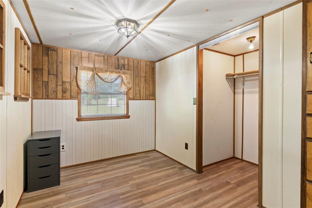 1500 County Road 404 Comanche, TX 76442 - Photo 21 of 39 a view of a hallway with wooden floor and cabinet with a chandelier