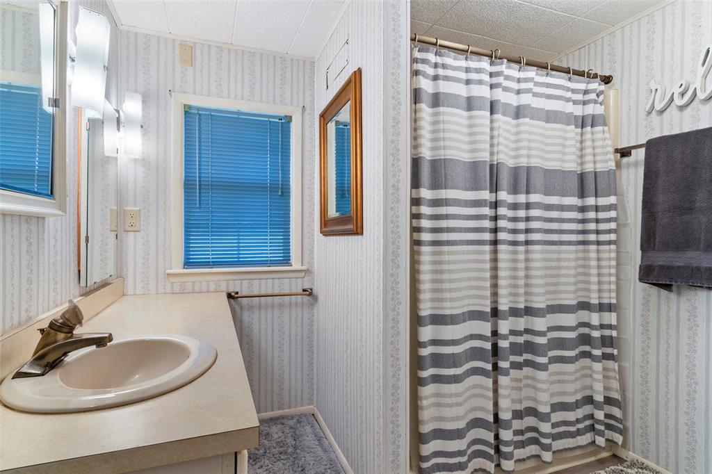 1500 County Road 404 Comanche, TX 76442 - Photo 22 of 39 a bathroom with a sink a mirror and a shower