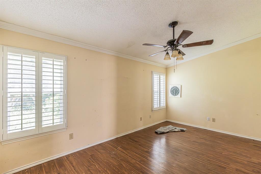 6504 Johnnie Street Watauga, TX 76148 - Photo 17 of 23 Room featuring wood-finish flooring, white crown molding, and two windows with white plantation shutters