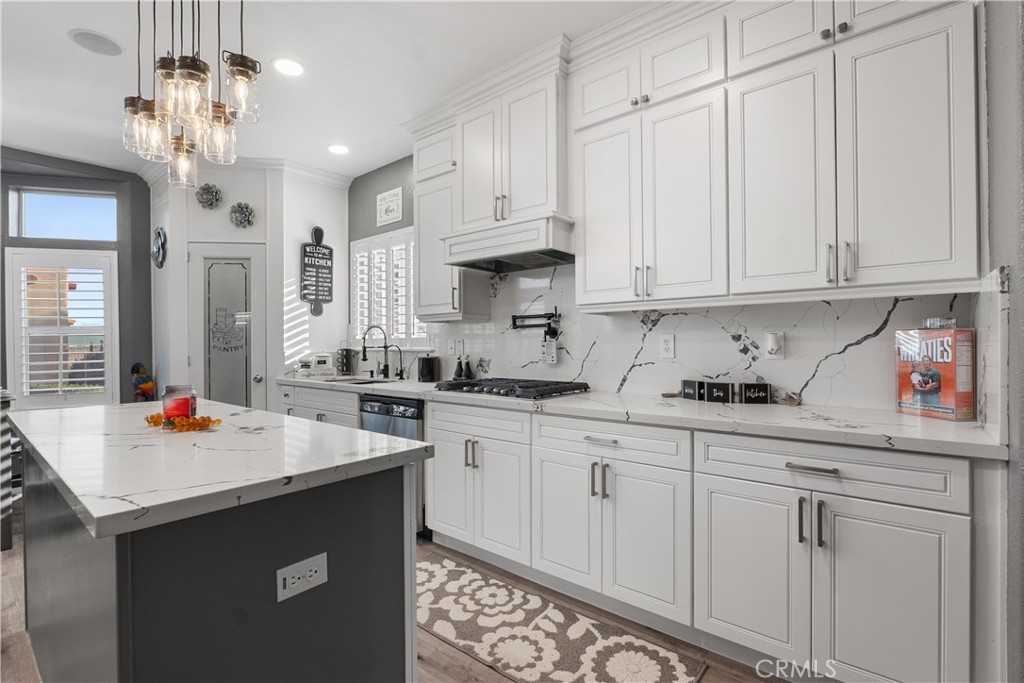 1188 Beach Drive Needles, CA 92363 - Photo 5 of 41 a kitchen with stainless steel appliances granite countertop a sink dishwasher and white cabinets with wooden floor