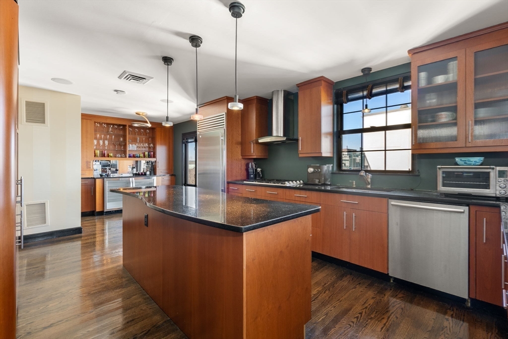 227 Summit Avenue, Unit E401 Brookline, MA 02446 - Photo 11 of 38 a kitchen with stainless steel appliances granite countertop a sink a stove and a wooden floors