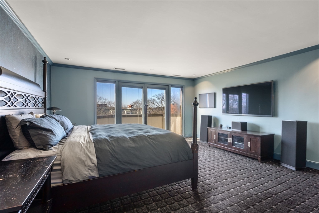 227 Summit Avenue, Unit E401 Brookline, MA 02446 - Photo 18 of 38 a bedroom with a bed and wooden cabinets