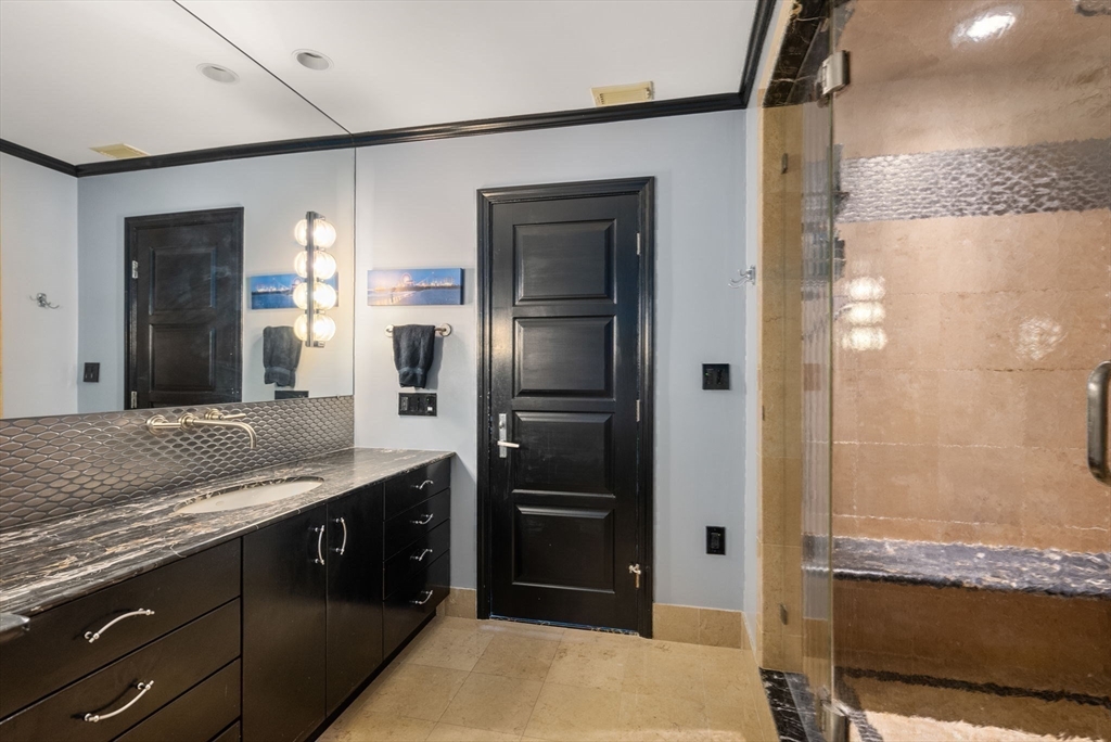 227 Summit Avenue, Unit E401 Brookline, MA 02446 - Photo 23 of 38 a bathroom with a granite countertop sink and a mirror