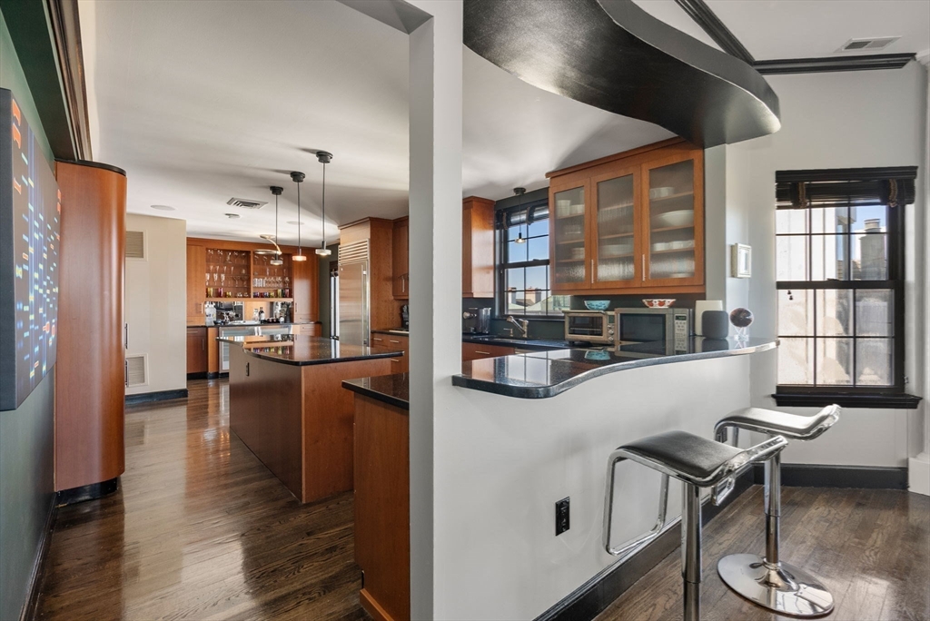 227 Summit Avenue, Unit E401 Brookline, MA 02446 - Photo 10 of 38 a kitchen with a table chairs and a wooden floor