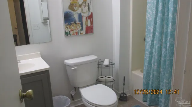a bathroom with a toilet and a shower curtain