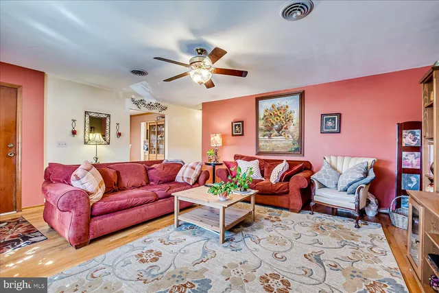 a living room with furniture ceiling fan and a rug