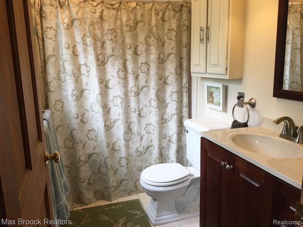 9895 Rattalee Lake Road Clarkston, MI 48348 - Photo 10 of 34 Master bath with newer vanity and a jet tub hiding behind the shower curtain.